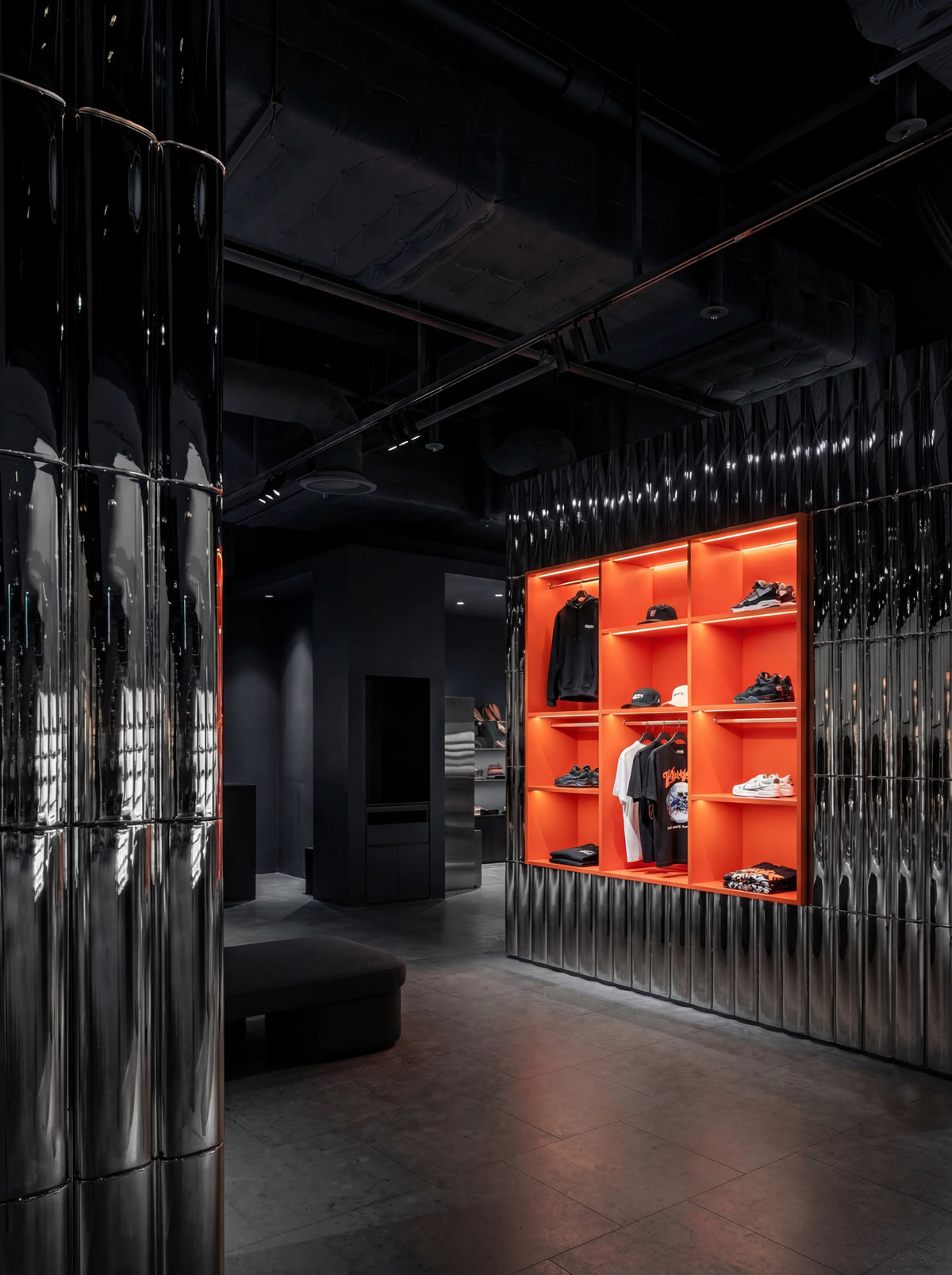 Modern interior design with orange shelves and reflective black walls.