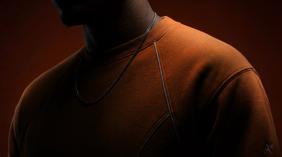 Person wearing a brown shirt with a dark background