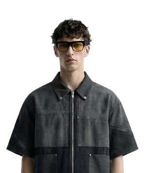 Man wearing a dark denim jacket and sunglasses on a white background