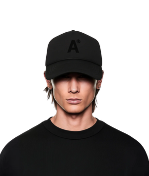 Person wearing a black cap with a logo on a white background