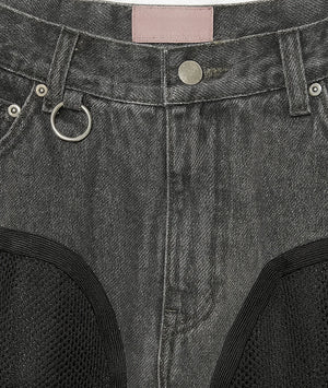 Close-up of a gray denim fabric with stitching details and a pink label.