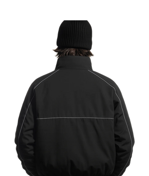 Person wearing a black jacket with white accents on a white background