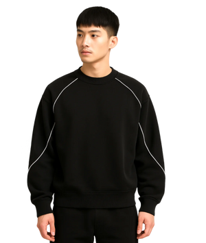Person wearing a black sweatshirt with white accents on a white background
