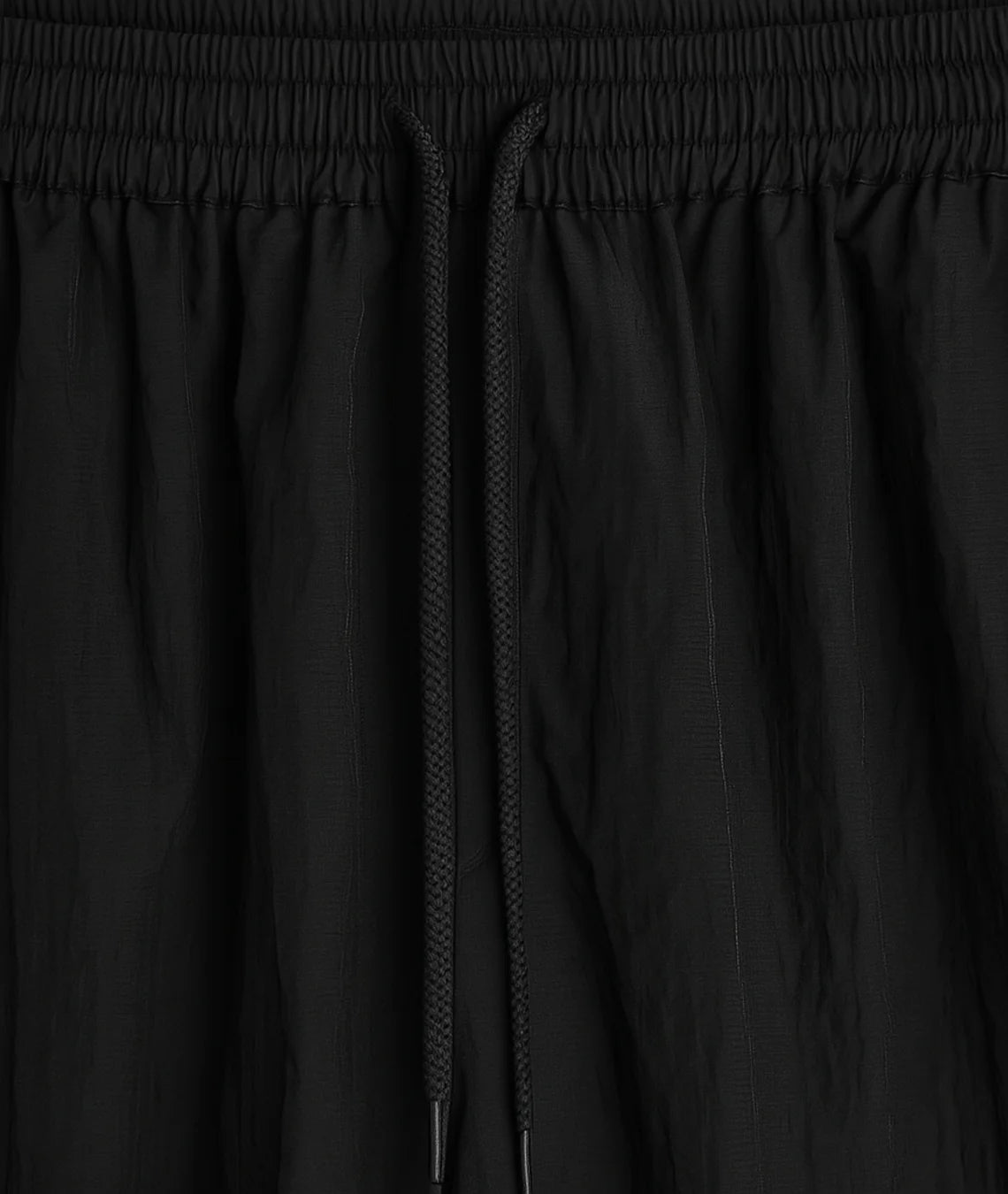 Close-up of black pants with a focus on the waistband and fabric texture.