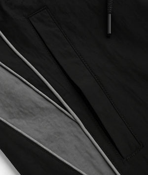 Close-up of a black jacket with a zipper detail on a dark background