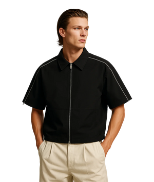 Man wearing a black short-sleeve jacket with white piping on a white background