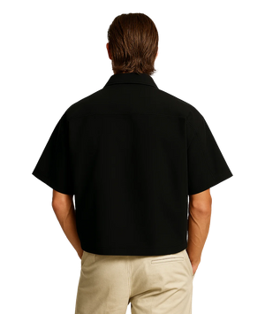 Person wearing a black shirt and beige pants on a white background