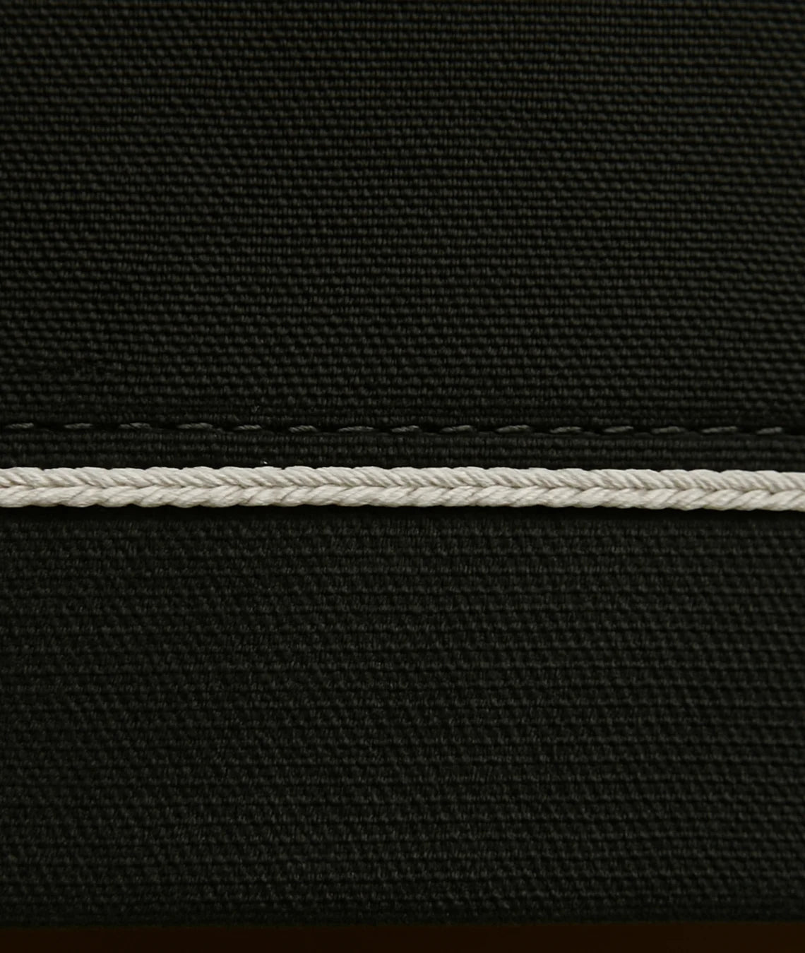 Close-up of black fabric with a white stitching detail