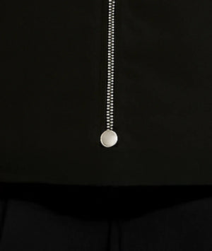 Close-up of a zipper on a black garment with a white background