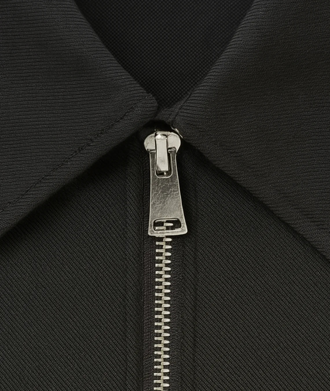 Close-up of a black jacket with a silver zipper