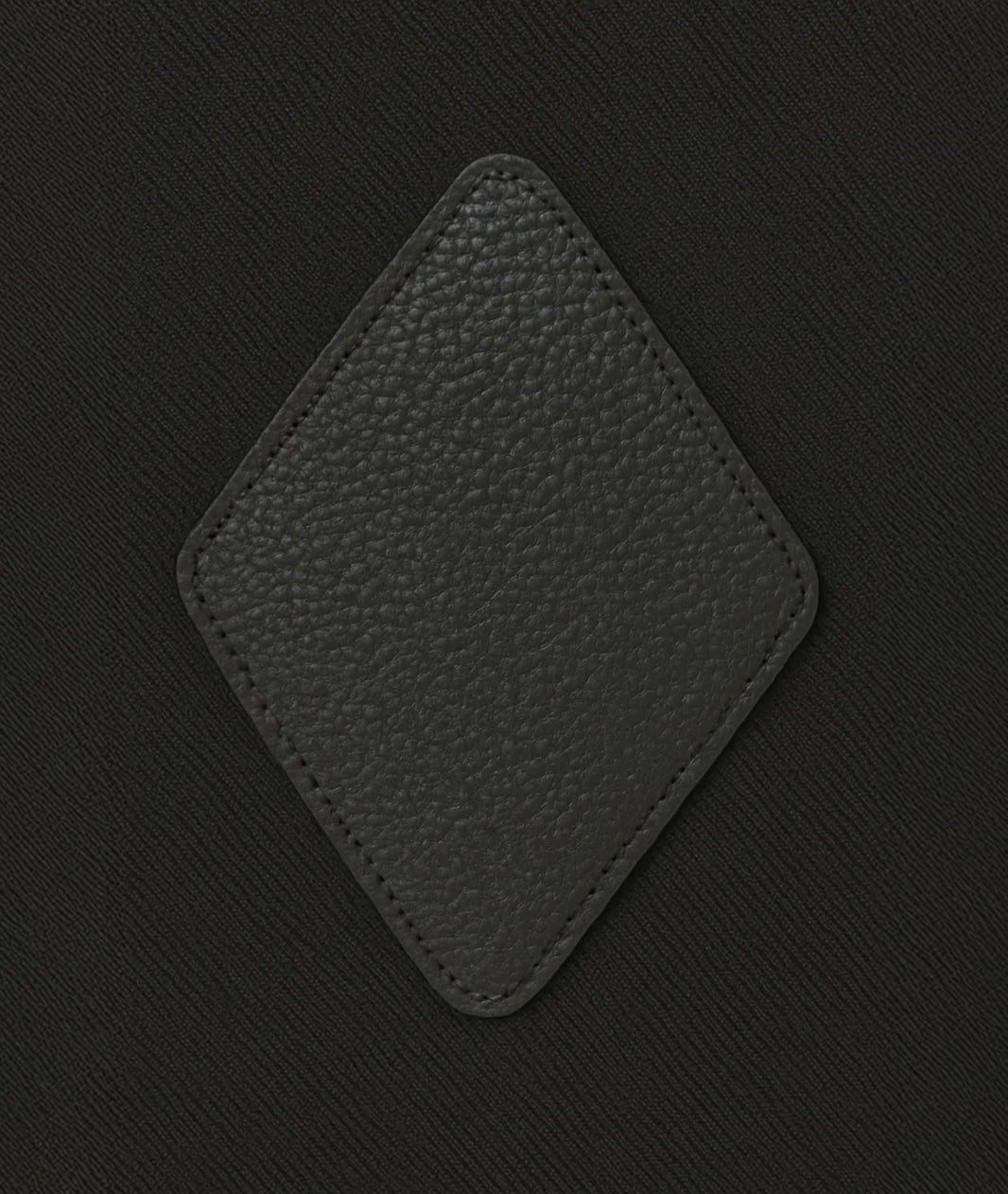 Black textured square patch on a black background