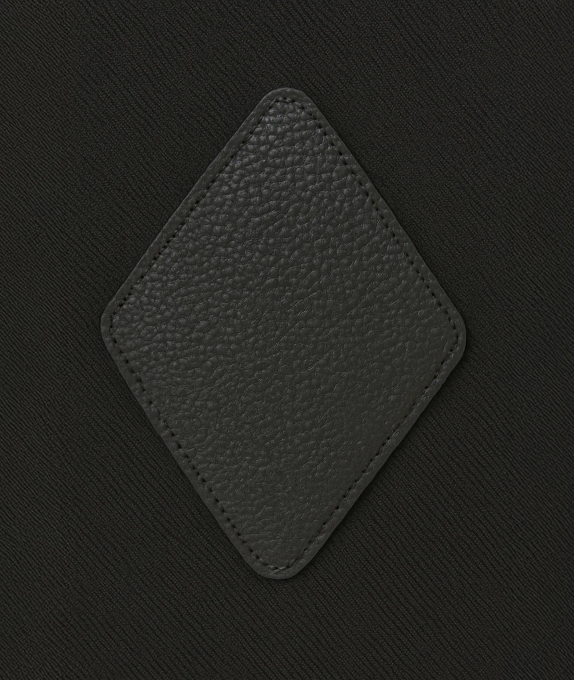 Black textured square patch on a black background