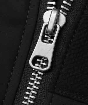 Close-up of a metal zipper on black fabric