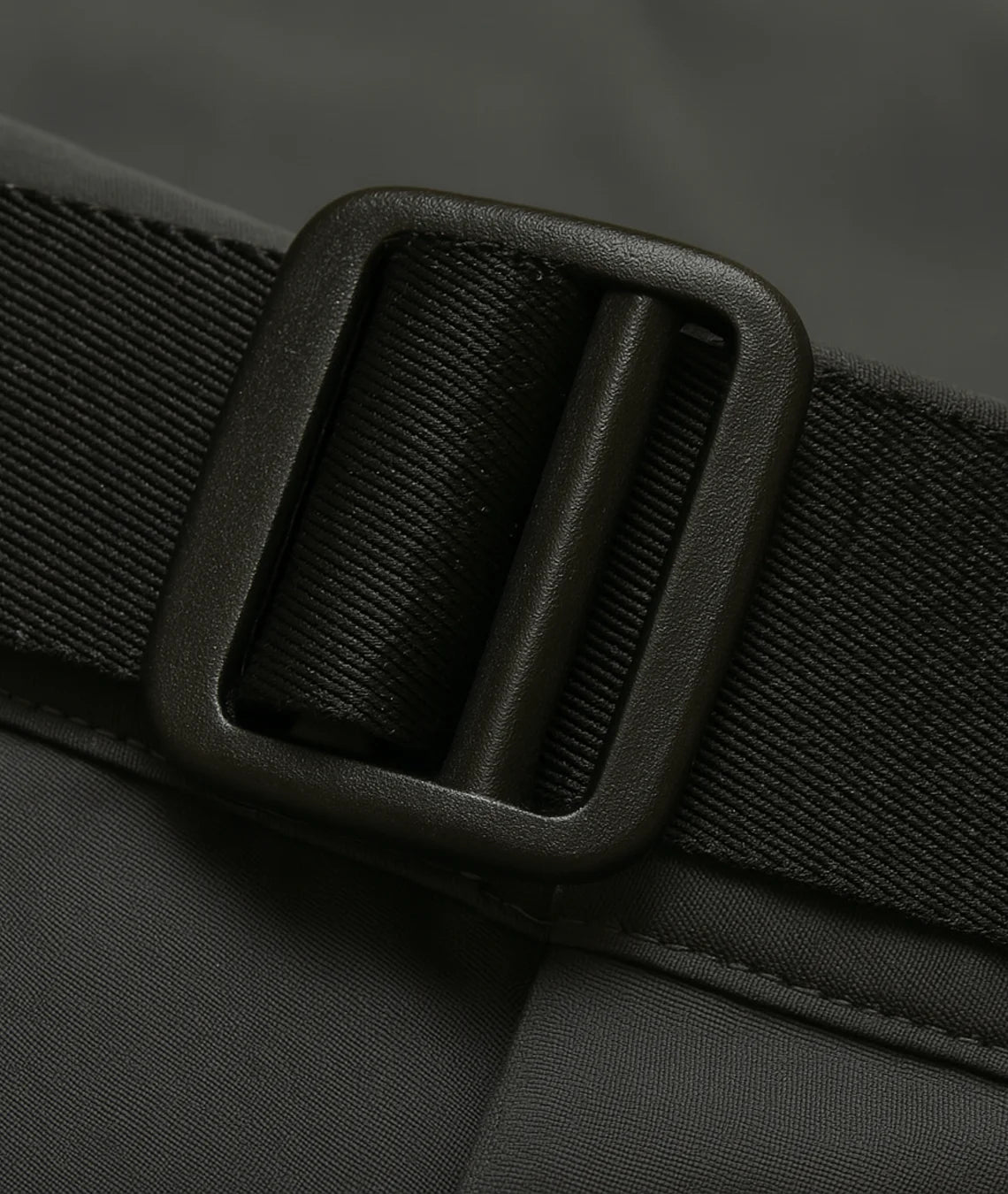 Close-up of a black belt with a buckle on a dark background