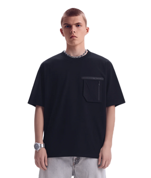 Person wearing a black t-shirt with a pocket on a white background