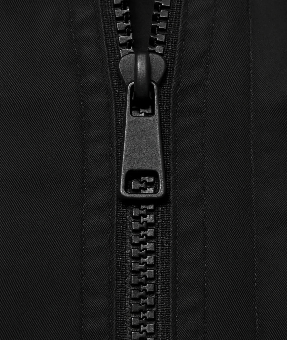 Close-up of a black zipper on black fabric