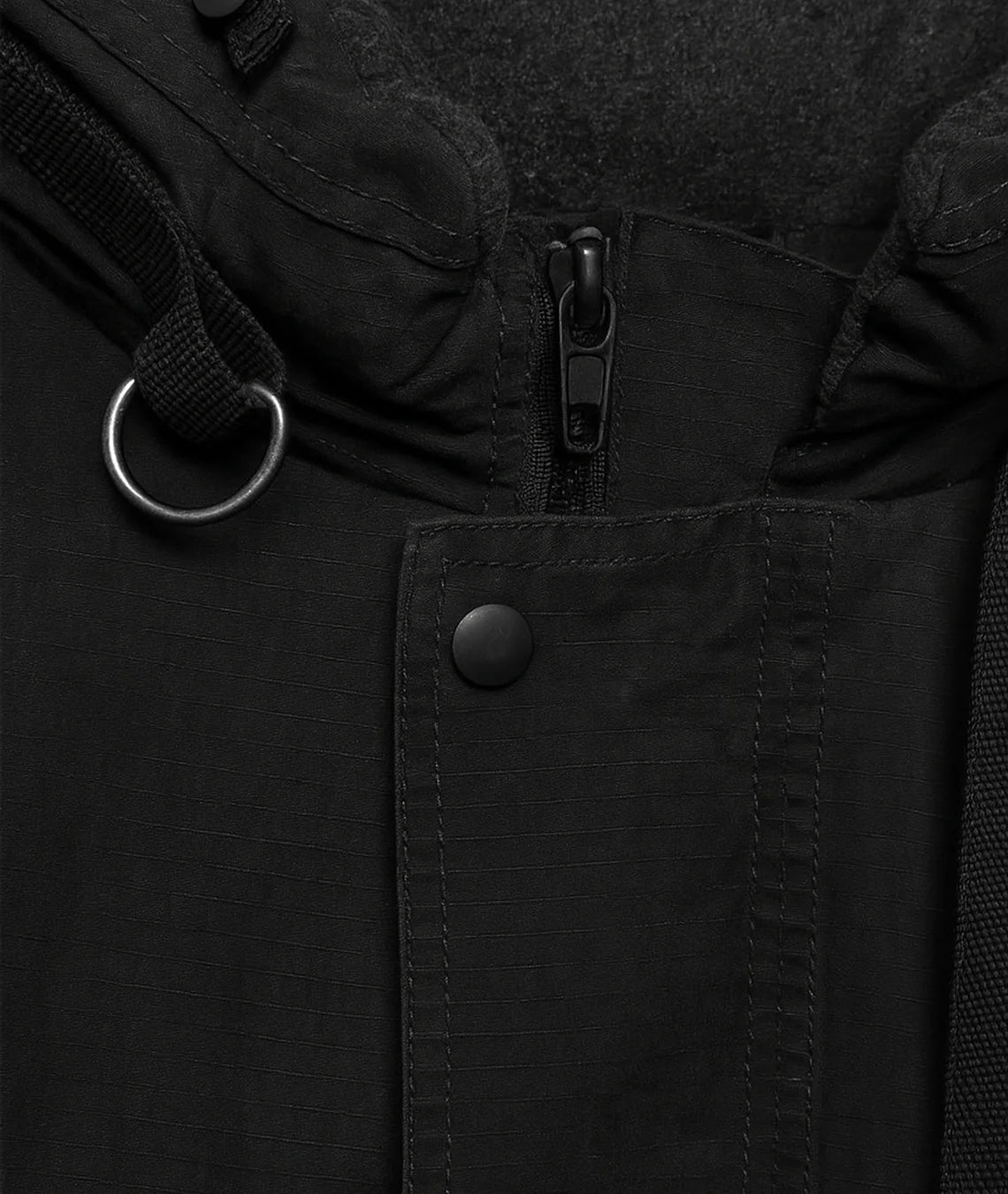 Close-up of a black jacket with a zipper and button details.