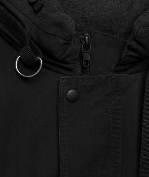 Close-up of a black jacket with a zipper and button details.