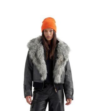 Person wearing a gray coat with fur collar and an orange beanie on a white background