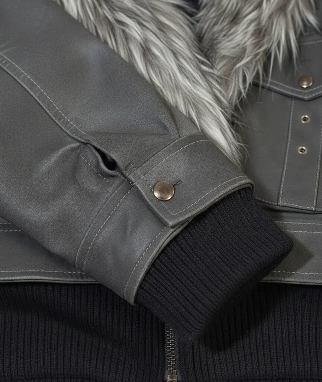 Close-up of a gray jacket with fur lining and black ribbed cuffs.