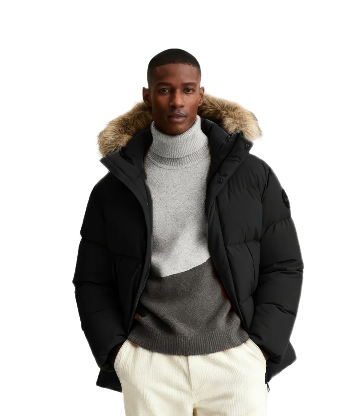 Man wearing a black puffer jacket with fur hood on a white background