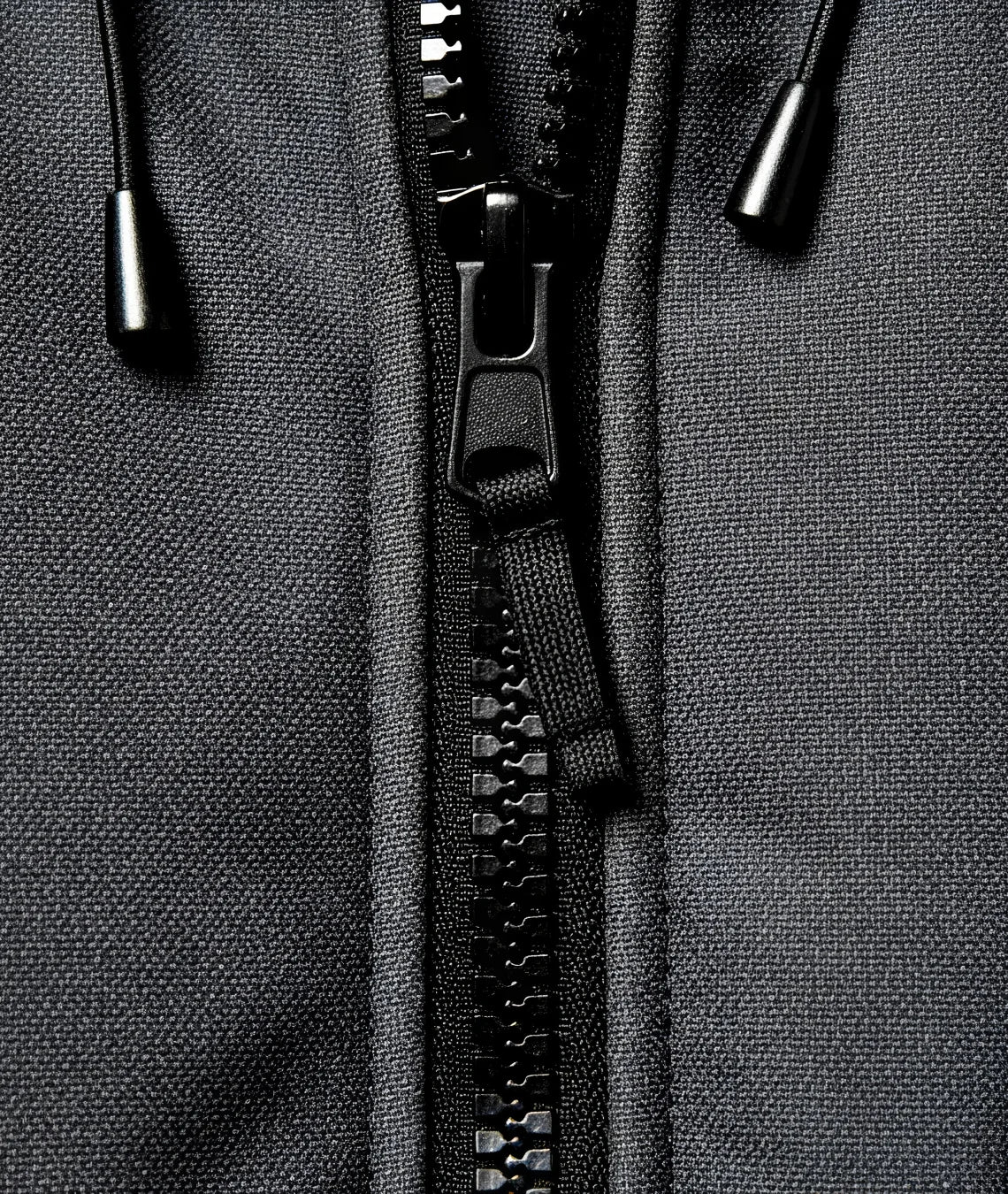 Close-up of a black zipper on a gray fabric background