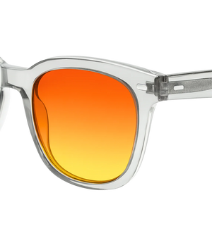 Close-up of a pair of sunglasses with a clear transparent frame and a square-shaped orange-to-yellow gradient lens, shown against a white background.