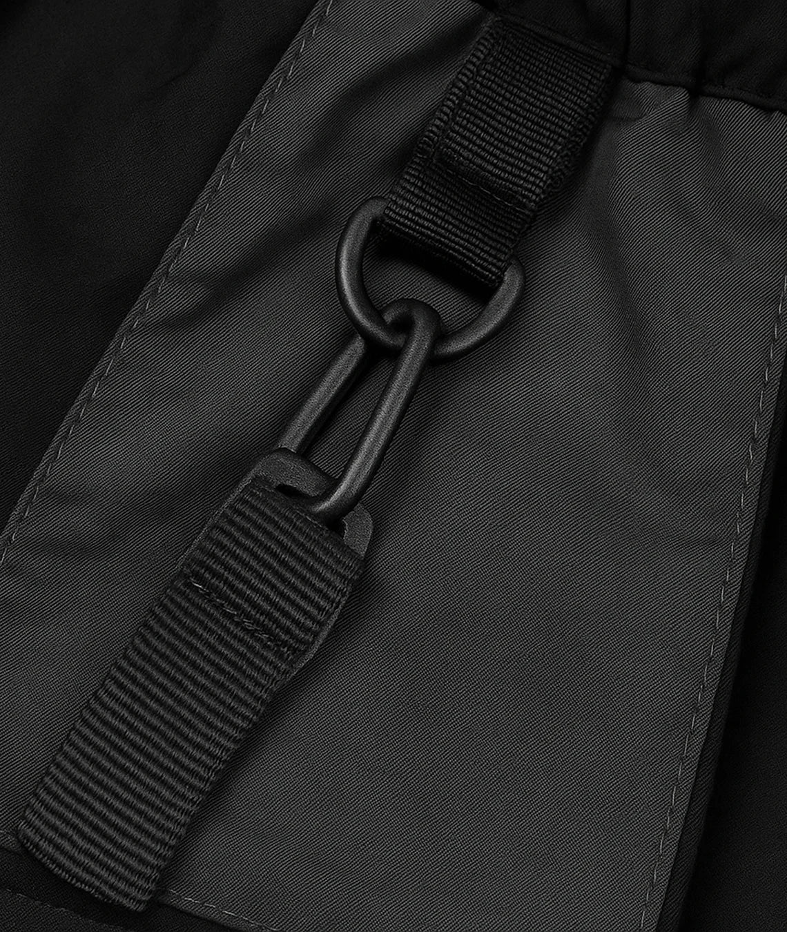 Close-up of a black strap and buckle on a dark gray fabric background