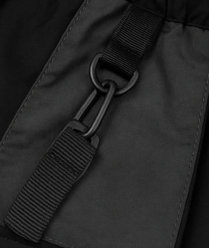 Close-up of a black strap and buckle on a dark gray fabric background