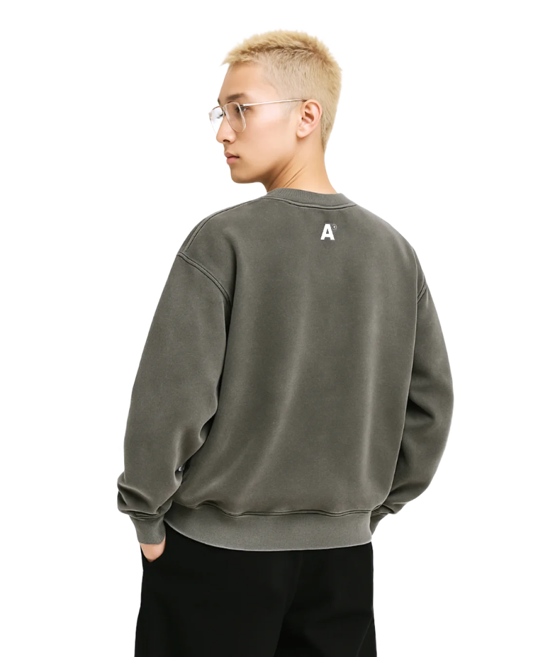 Person wearing a green sweatshirt with a logo on the back against a white background
