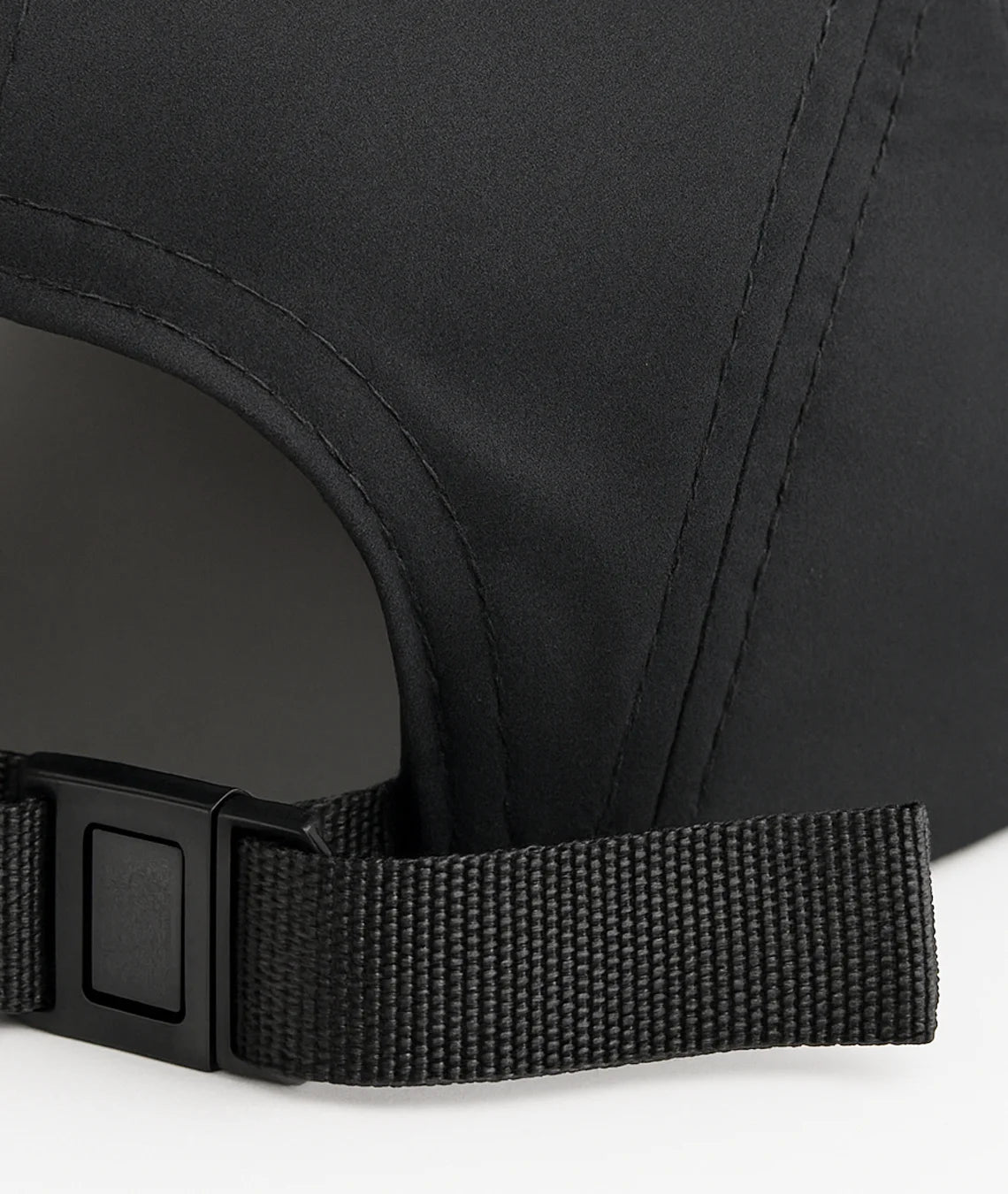 Close-up of a black cap with a strap on a white background