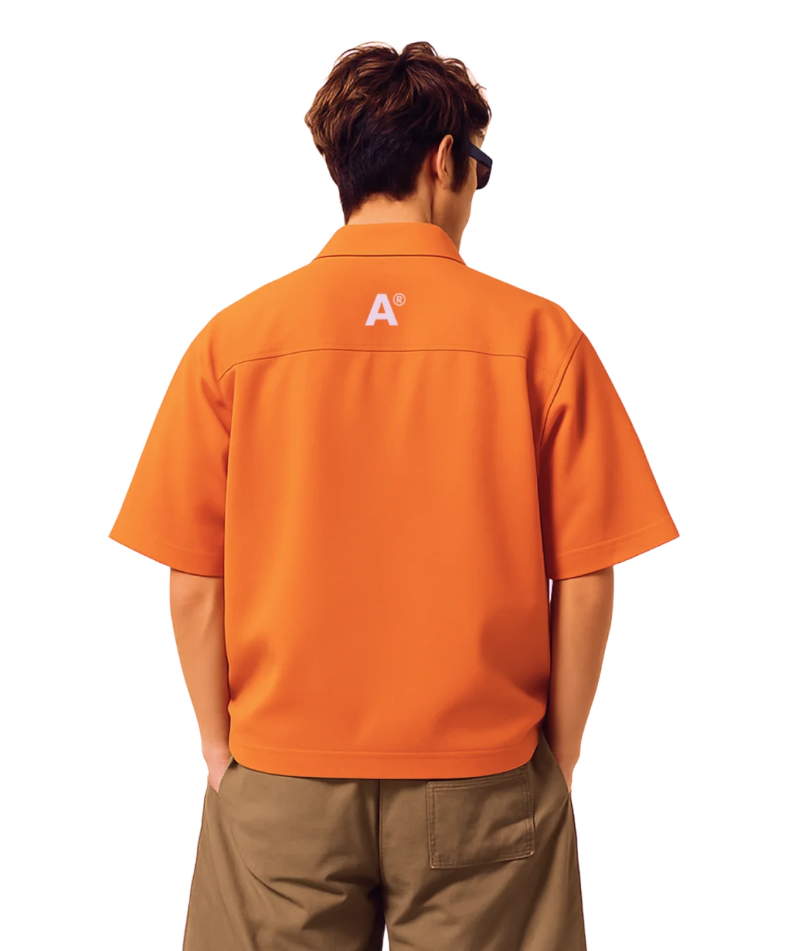Person wearing an orange shirt with a logo on the back, standing against a white background