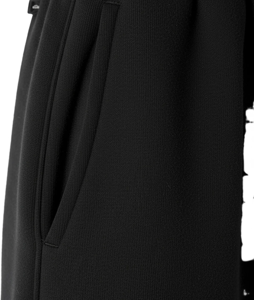 Close-up of a black garment with a tie detail on a white background