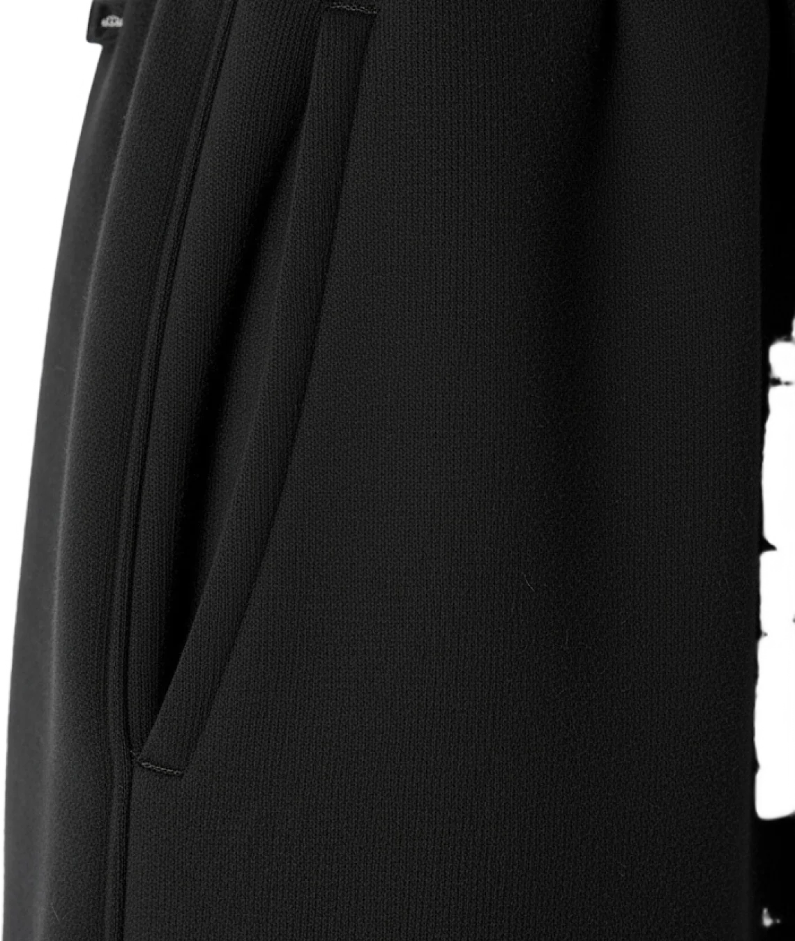 Close-up of a black garment with a tie detail on a white background