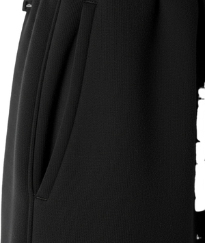 Close-up of a black garment with a tie detail on a white background
