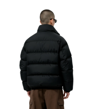 Person wearing a black puffer jacket on a white background