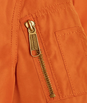 Close-up of a gold zipper on an orange jacket