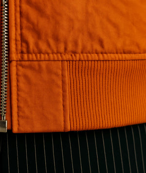 Close-up of an orange jacket with a zipper detail