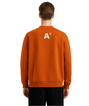 Person wearing an orange sweatshirt with a logo on the back against a white background