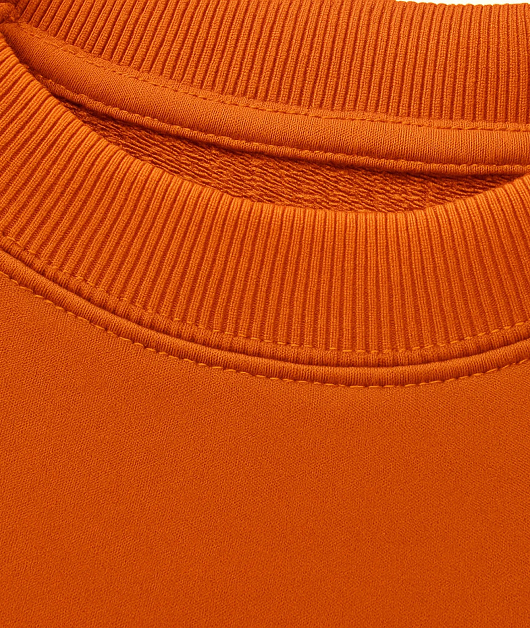 Close-up of an orange sweater with a ribbed neckline.