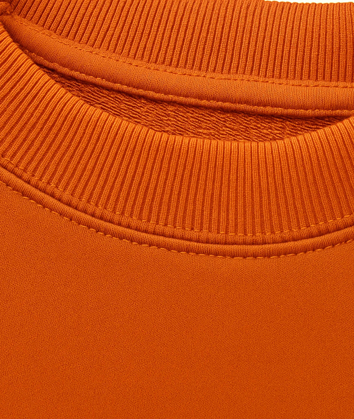 Close-up of an orange sweater with a ribbed neckline.
