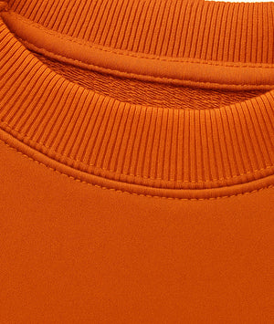 Close-up of an orange sweater with a ribbed neckline.