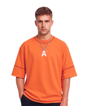 Person wearing an orange t-shirt with a logo on a white background
