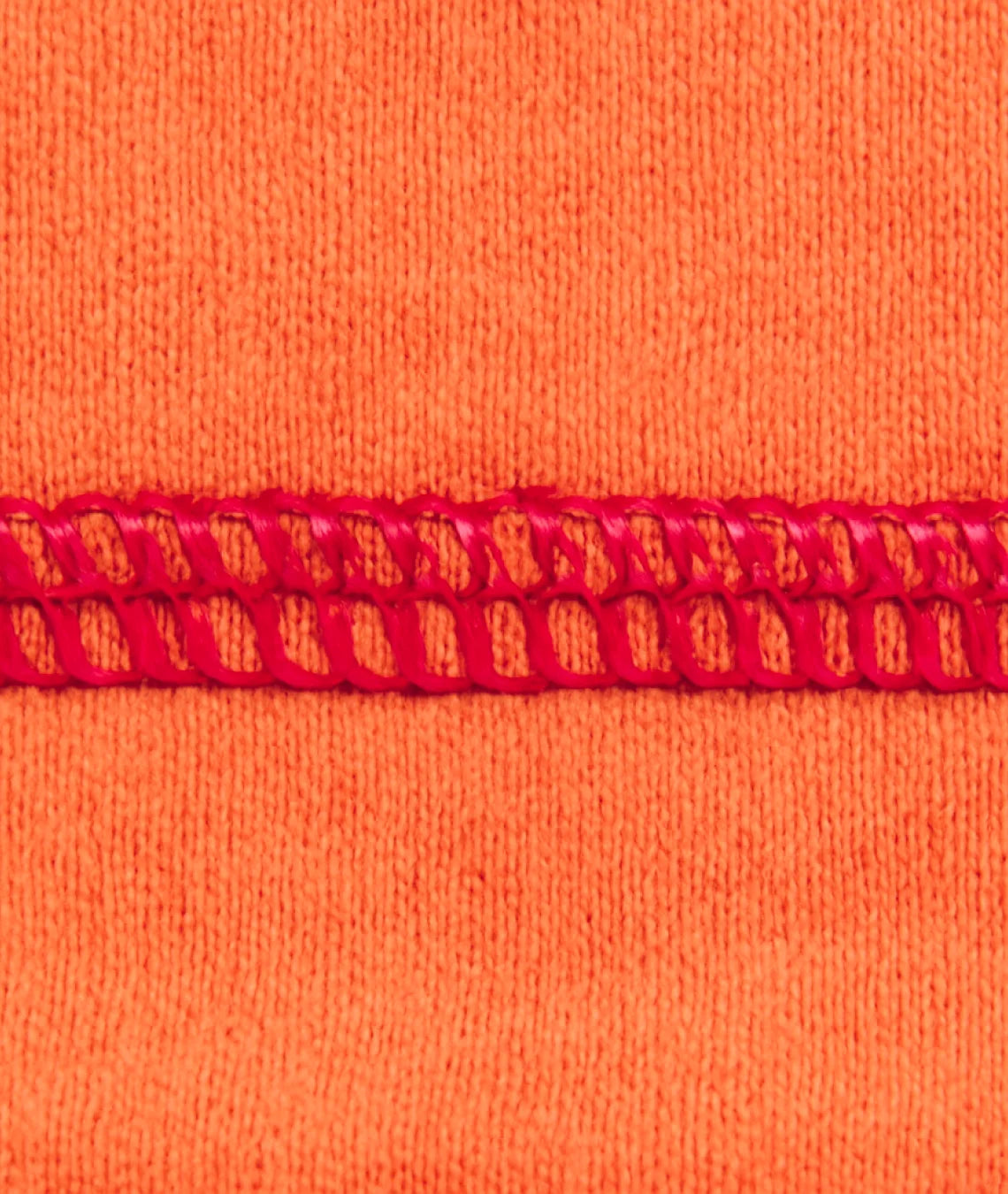 Close-up of orange fabric with red lace trim
