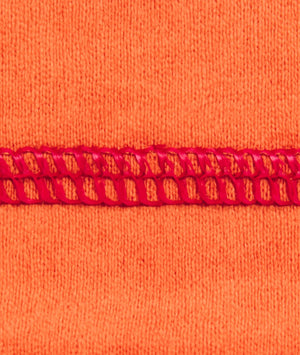 Close-up of orange fabric with red lace trim