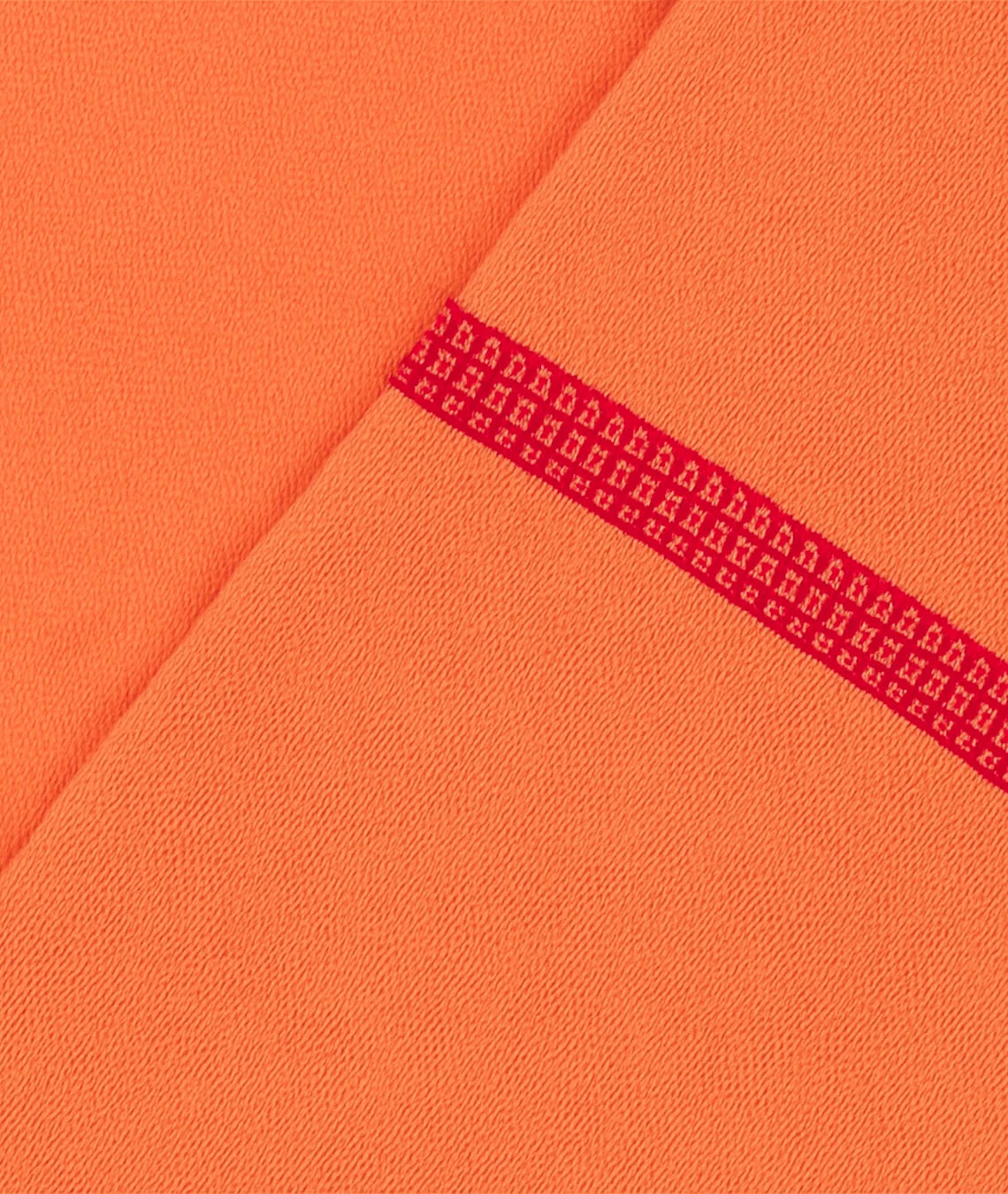 Close-up of orange fabric with a red patterned line