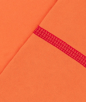 Close-up of orange fabric with a red patterned line