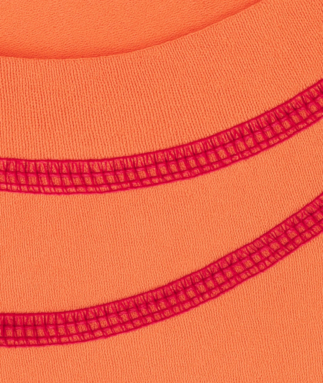 Close-up of orange fabric with red stitching detail