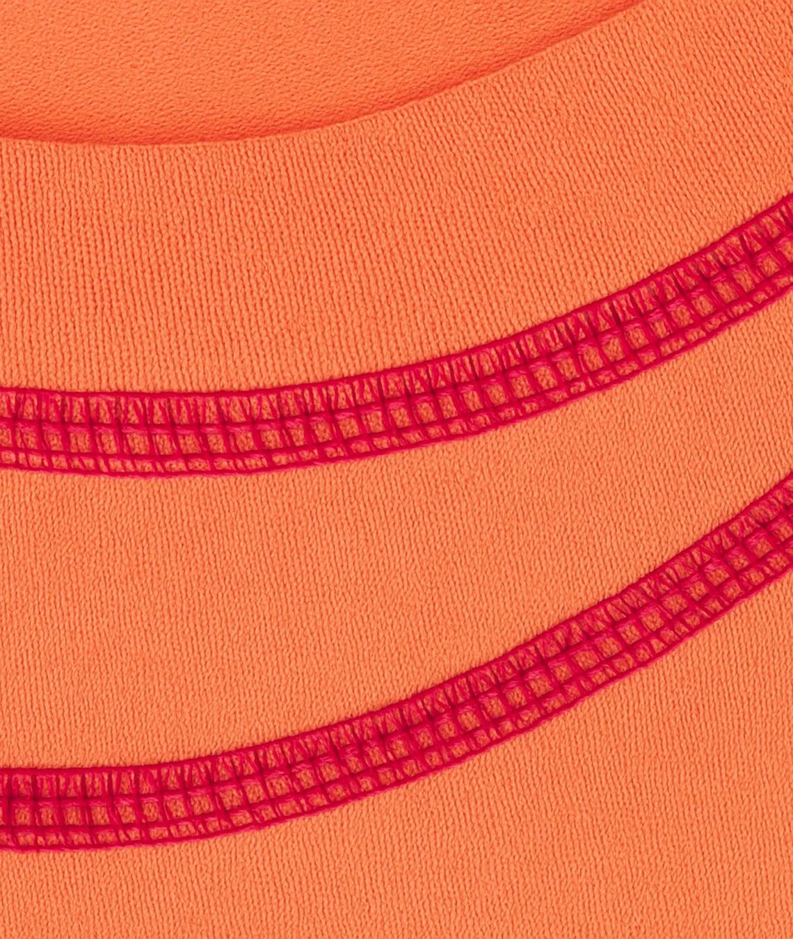 Close-up of orange fabric with red stitching detail