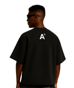 Person wearing a black t-shirt with a logo on the back against a white background